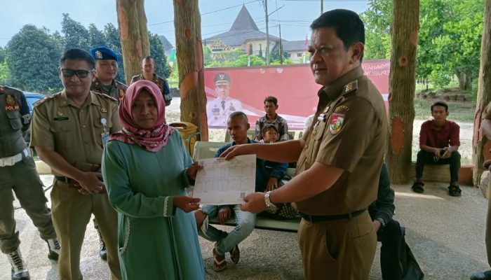 Tinjau Pelayanan Disdukcapil, Pj Bupati Turut Melayani Serahkan KK Kepada Warga